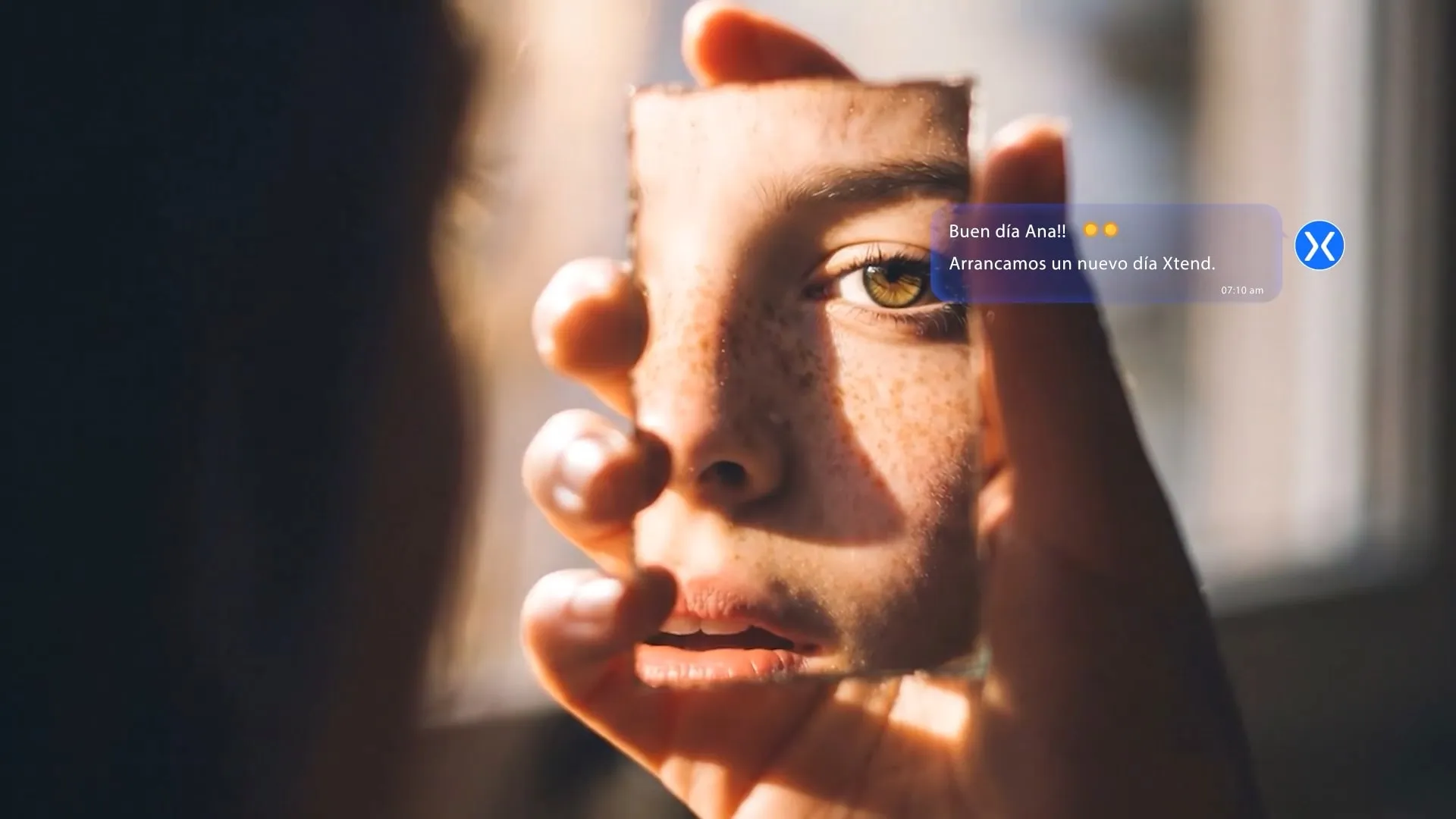Persona sosteniendo un espejo que refleja su rostro con la luz de la mañana